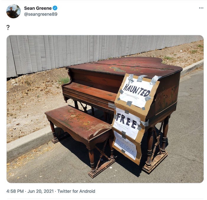 tweet from @seangreen89 with a question mark and a picture of a piano with signs on it that read "haunted", "free", and "priceless antique"