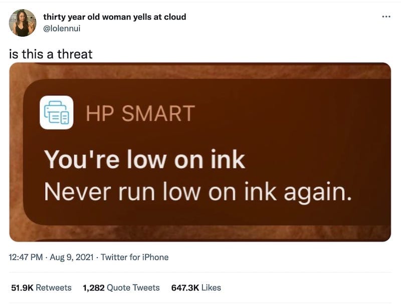 screenshot of a tweet by @lolennui
 that reads, "is this a threat". The tweet contains a screenshot of an HP Smart notification that reads "You're low on ink Never run low on ink again."
