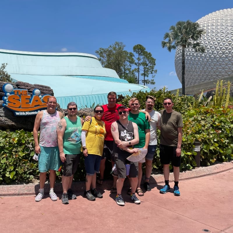 A picture of david and their friends and partners in front of The Seas ride and the Epcot Ball at Epcot in Disney World